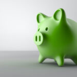 Closeup of a green piggy bank on a gray surface